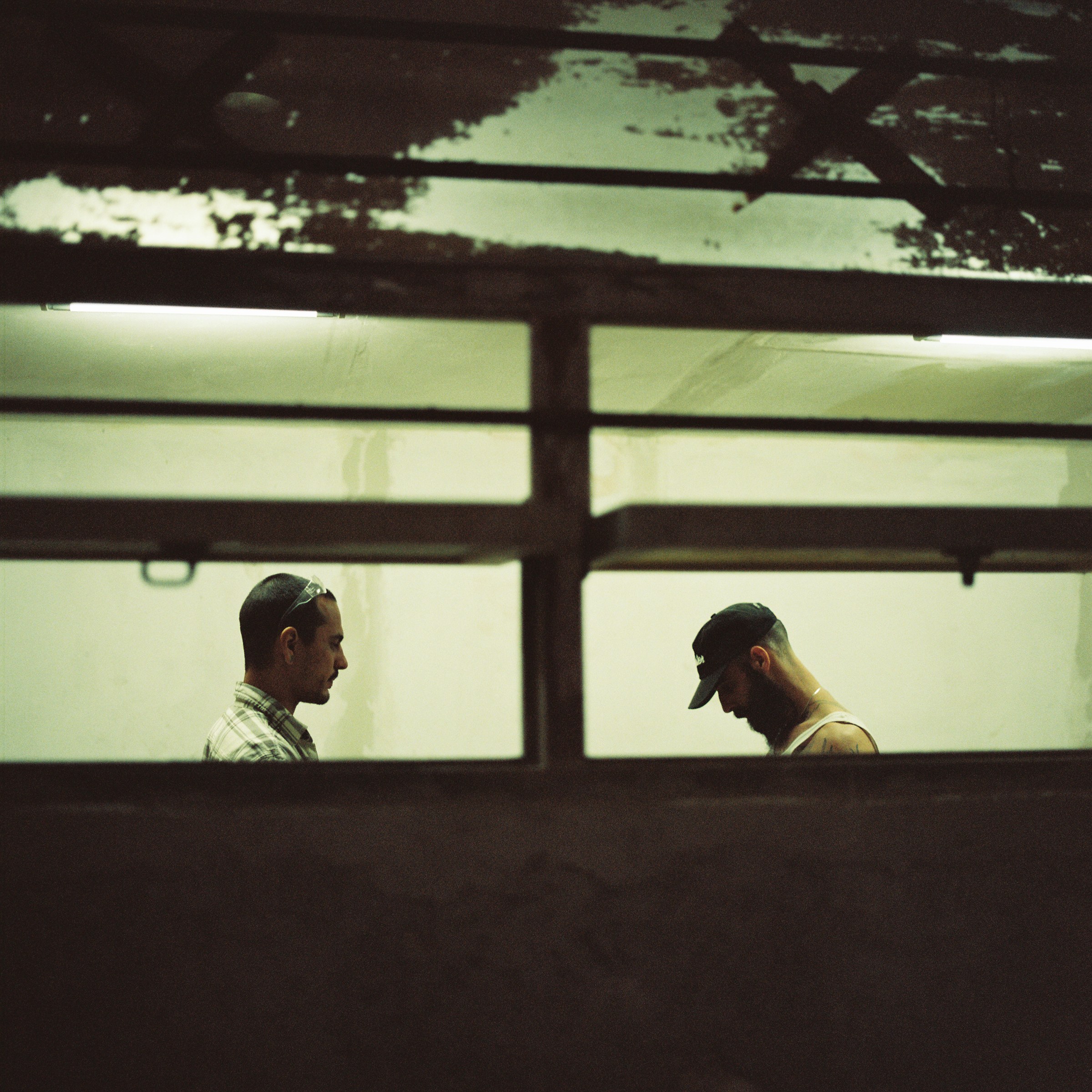 Two builders seen through the workshop window frames
