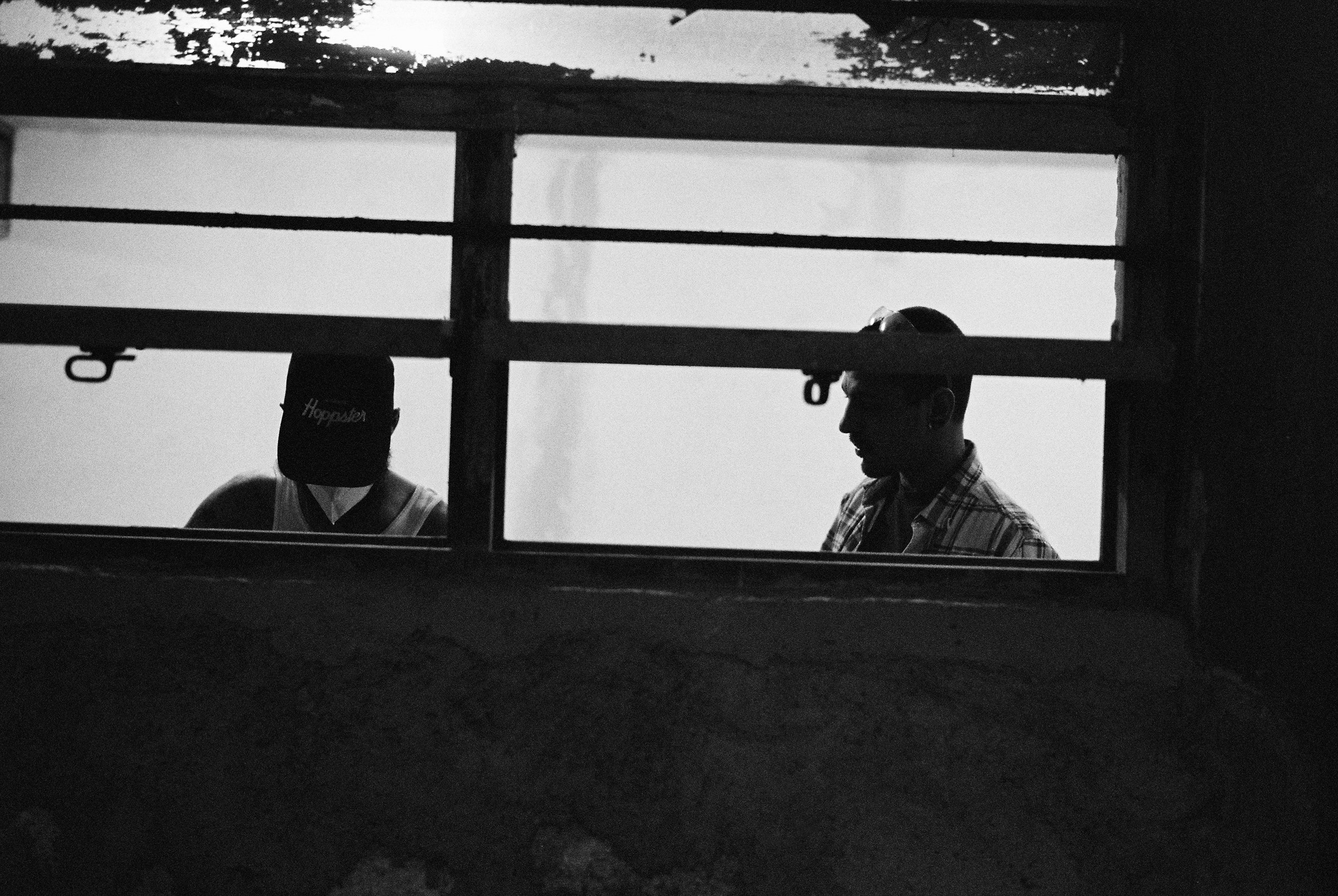 Two silhouettes through the long workshop windows