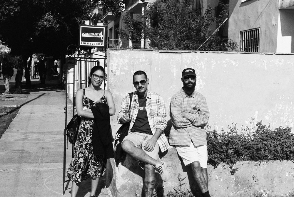 Three of the crew against a wall in the sun