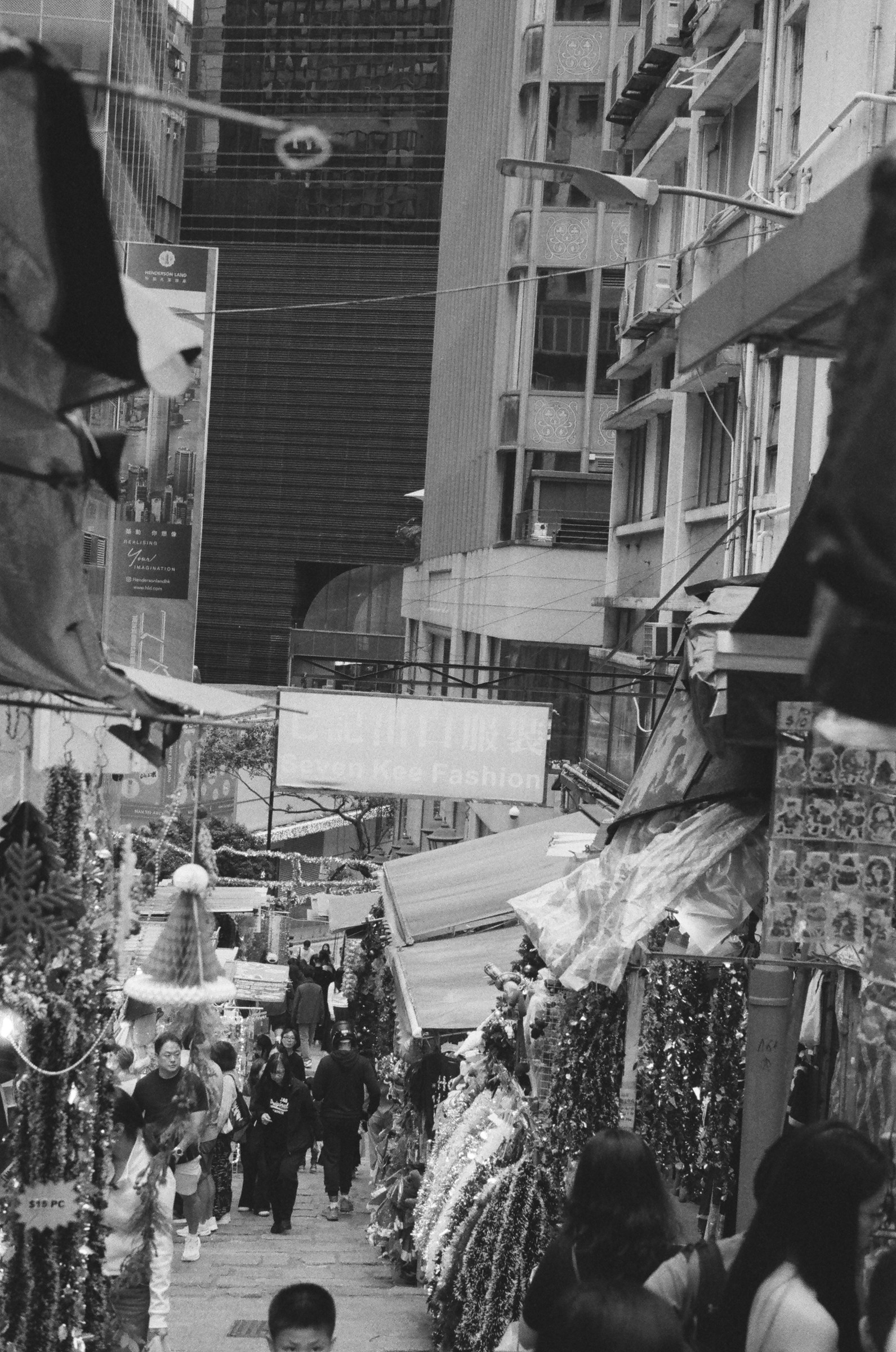 Market lane crowded with stalls between tall buildings