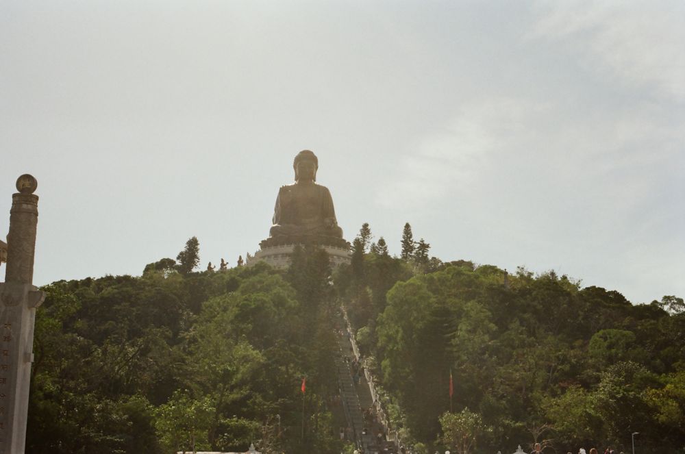 The Buddha small on its hilltop from a distance