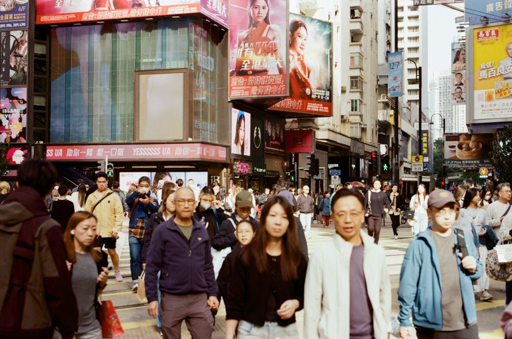 Crowd crossing in Mong Kok under billboard screens