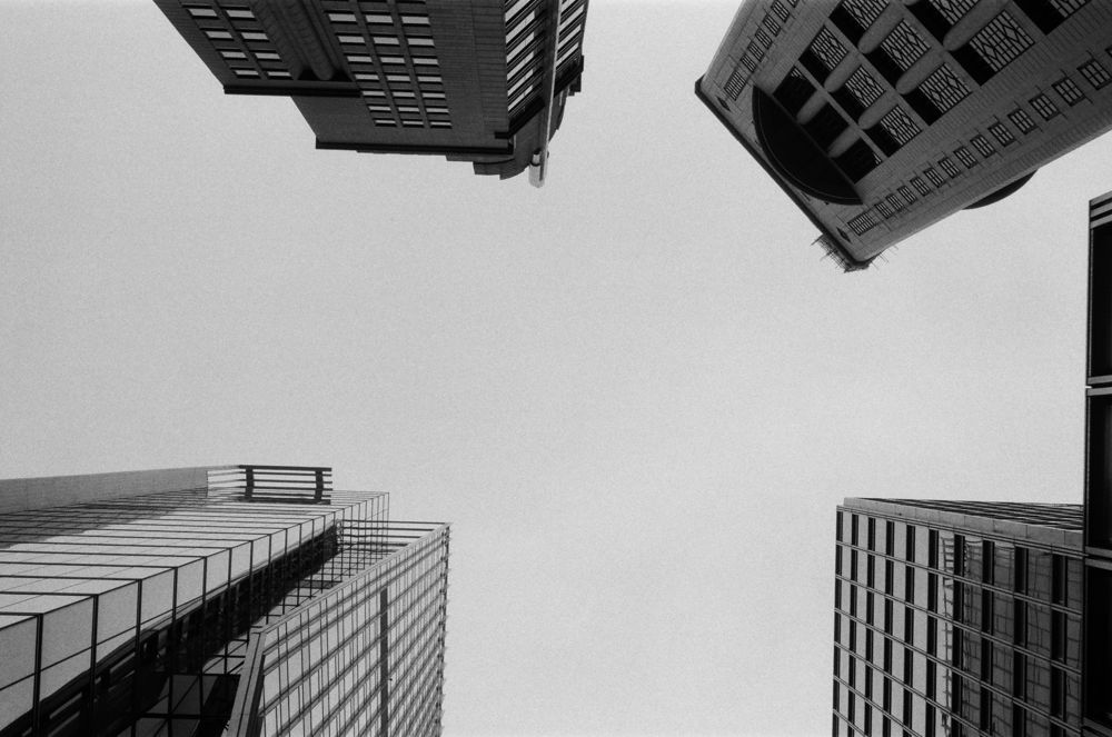 Looking straight up between towers, black and white