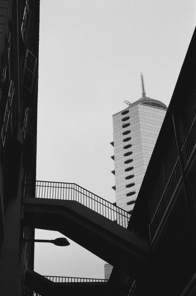 Footbridge silhouette against a tower